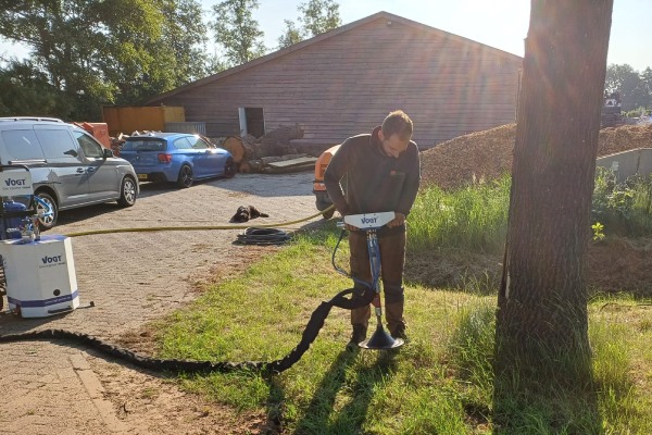 Boomverzorger van Groentechniek Klomp past grond ploffen toe.