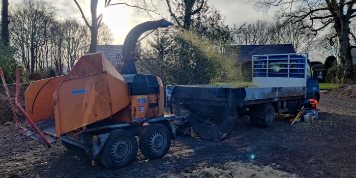 Takkenversnipperaar spuit snippers in de laadbak van de bedrijfswagen van Groentechniek Klomp.