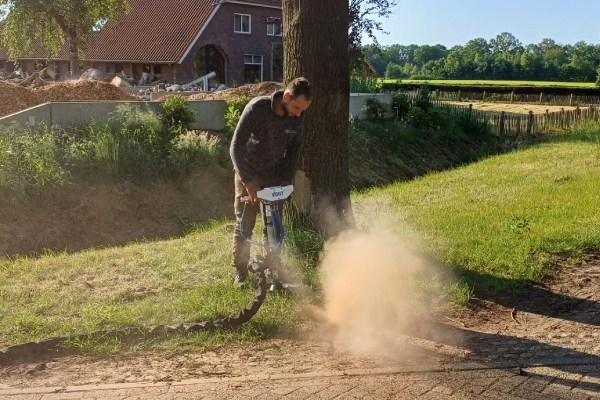 Boomverzorging in Rotterdam met specialistisch materieel voor zorgvuldig werk rond bomen Medewerker voert grondwerk uit bij een boom tijdens boomverzorging in Rotterdam.
